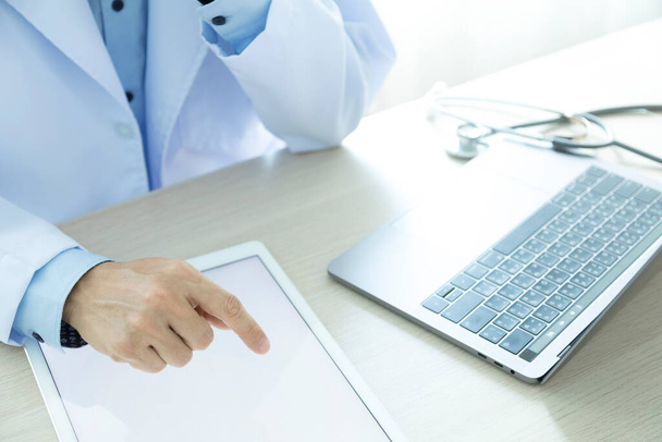 врач работает с планшетным компьютером и ноутбуком. медицинская концепция. - Фото, изображение