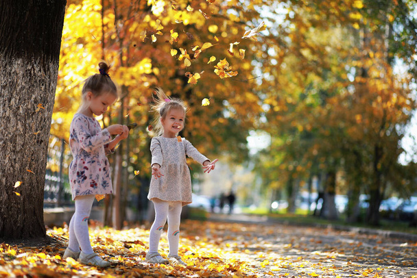 Caduta di foglie nel parco. Bambini per una passeggiata nel parco autunnale. Famiglia. Caduta. Felicità. - Foto, immagini