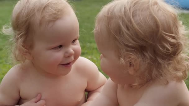 Primer plano divertido lindo bebé gemelos riendo pasar tiempo juntos pueblo al aire libre campo - Metraje, vídeo