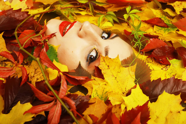 Artistiek conceptueel herfstportret. Kleurrijke bladeren. Bladeren van bomen rond emotioneel gezicht. De herfst komt eraan.. - Foto, afbeelding