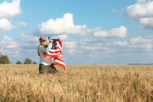 Людина махаючи американським прапором стоячи на сільськогосподарському полі, свята, патріотизм, гордість, свобода, політичні партії, іммігрант - Фото, зображення