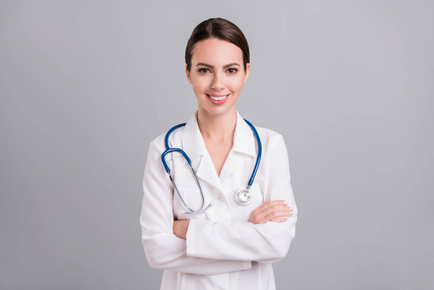 Photo of confident charming young lady doctor workwear hands folded isolated grey color background - Fotografie, Obrázek