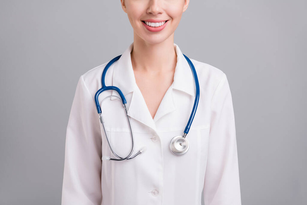 Cropped photo of sweet adorable young doc woman dressed white coat smiling isolated grey color background - 写真・画像