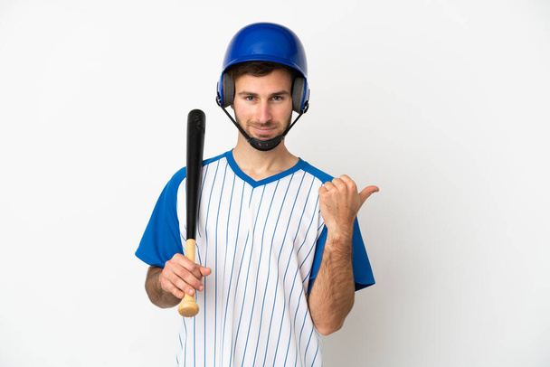 Young caucasian man playing baseball isolated on white background pointing to the side to present a product - Fotoğraf, Görsel
