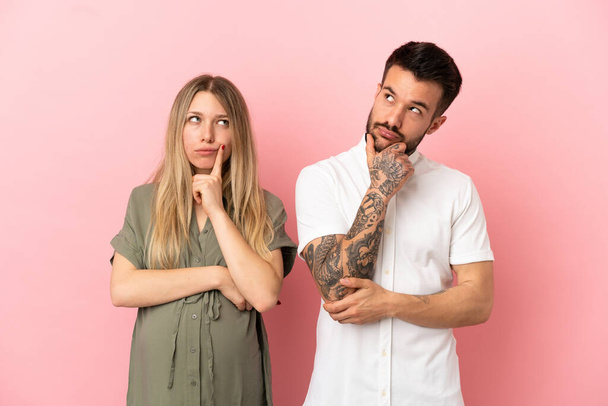 Pregnant woman and man over isolated pink background standing and thinking an idea - Photo, Image