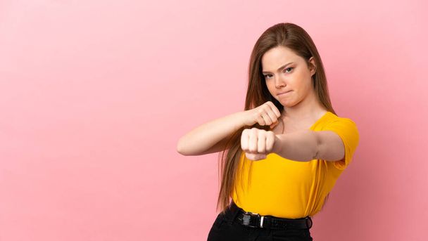 Adolescente sur fond rose isolé avec geste de combat - Photo, image