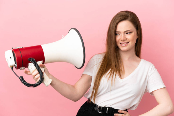 Teenager girl over isolated pink background holding a megaphone with stressed expression - Photo, Image