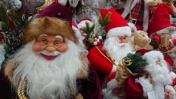 Кілька Миколаїв та інші різдвяні прикраси на полиці в магазині. - Фото, зображення