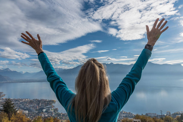 Happy blonde woman admiring the landscape and raising her arms. - Photo, Image