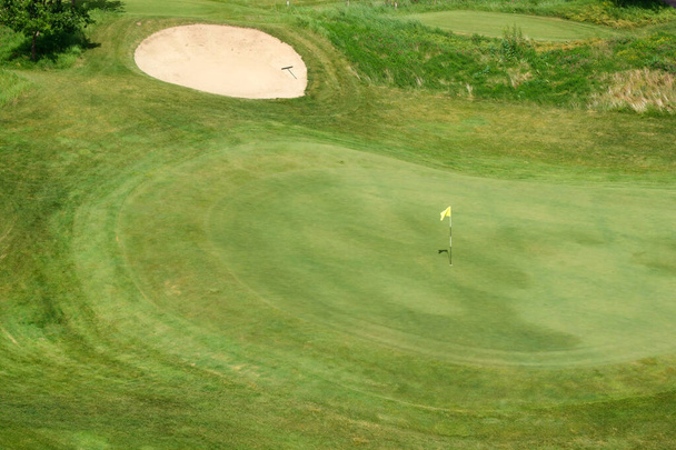 Golf sahasında yeşil çimenler ve delikler. Güneşli bir yaz gününde golf sahası. - Fotoğraf, Görsel