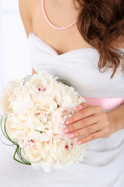 Bride holding wedding bouquet of white peonies, close-up, on light background - Foto, imagen