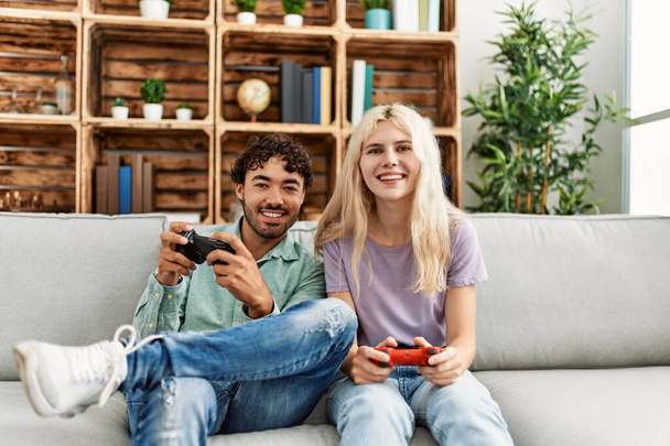 Young couple smiling happy playing video game at home. - Photo, Image