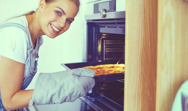 Happy young woman cooking pizza at home - Foto, Imagem