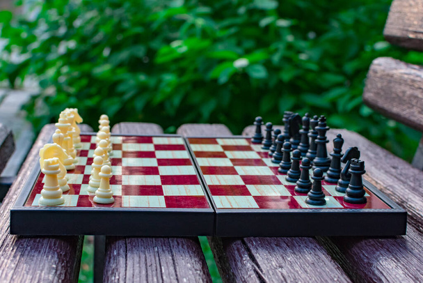 Día de Shehamat. Las piezas de ajedrez se colocan en un tablero de ajedrez sobre un fondo borroso de la naturaleza. Enfoque borroso. Desenfocar. - Foto, Imagen