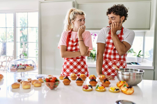 Néhány feleség és férj süteményt főz a konyhában, stresszesnek és idegesnek tűnnek, miközben a kezük körmöket harap. szorongás.  - Fotó, kép