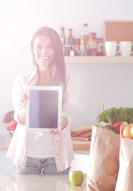 Young woman in the kitchen, using her ipad. Young woman - Photo, Image
