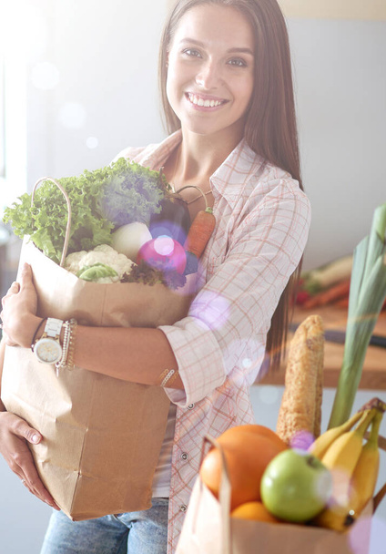 Young woman holding grocery shopping bag with vegetables. Young woman - Foto, imagen