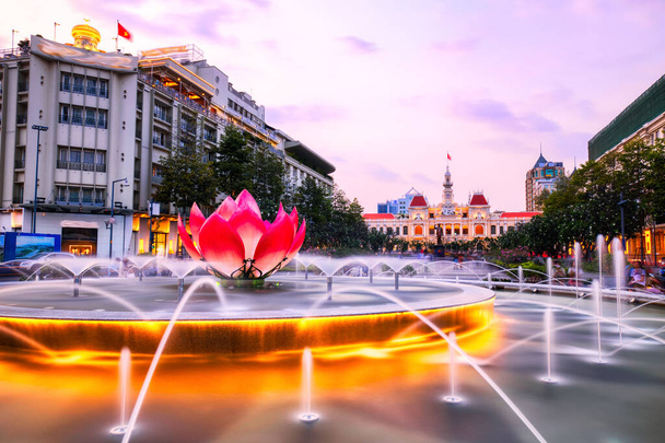 Fountain with People 's Committee of Ho Chi Minh City taustalla hämärässä, Vietnam    - Valokuva, kuva