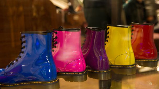 Pięć lśniących butów pod rząd w sklepie. Ten sam model, pięć różnych kolorów: niebieski, różowy, lila, żółty i czerwony. Londyn, Wielka Brytania, Europa - Zdjęcie, obraz