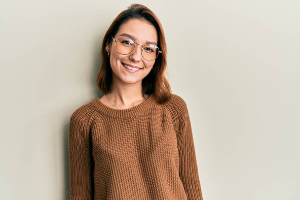Junge kaukasische Frau in lässiger Kleidung und Brille mit einem fröhlichen und kühlen Lächeln im Gesicht. Glück gehabt.  - Foto, Bild