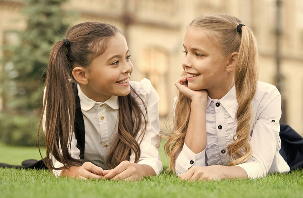 Feel natural. Happy children relax on green grass. Little children in school style. Beauty look of cute children. Fashion uniform. Child care and childhood. International childrens day - Photo, image