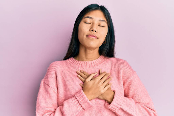 Young chinese woman wearing casual clothes smiling with hands on chest, eyes closed with grateful gesture on face. health concept.  - Foto, afbeelding