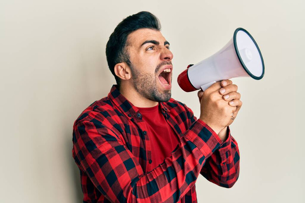 Hispanic man with beard screaming with megaphone - Foto, Imagem