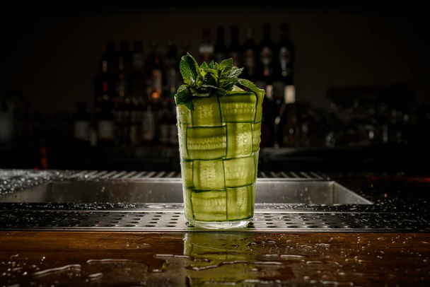 beautiful glass braided with green cucumber with a sprig of fresh mint - Фото, зображення