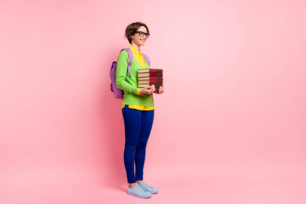 Full length photo of woman wear green cardigan spectacles rucksack holding book empty space isolated pink color background - Foto, Imagen