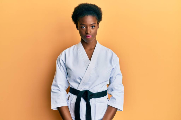 A fiatal afro-amerikai lány karate kimonót és fekete övet visel depressziós, és aggódik a szorongás, sír dühös és fél. szomorú kifejezés.  - Fotó, kép