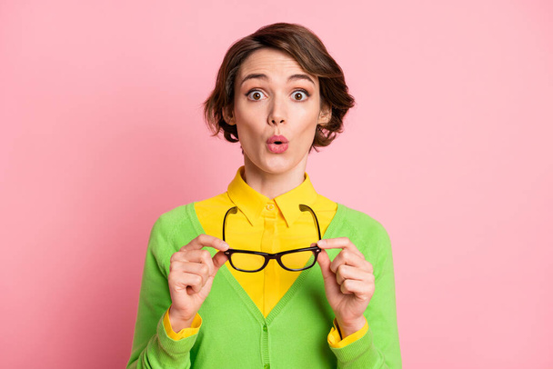 Photo of astonished attractive school girl wear green shirt hold take off glasses isolated on pink color background - Valokuva, kuva
