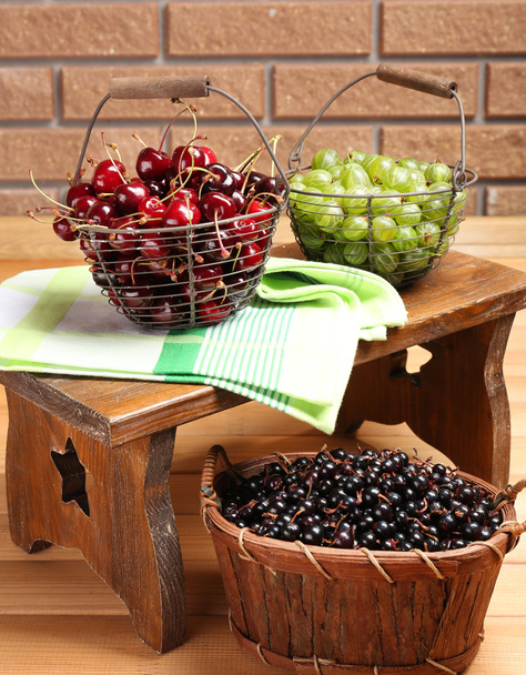 Fresh berries in baskets on wall background - Foto, imagen