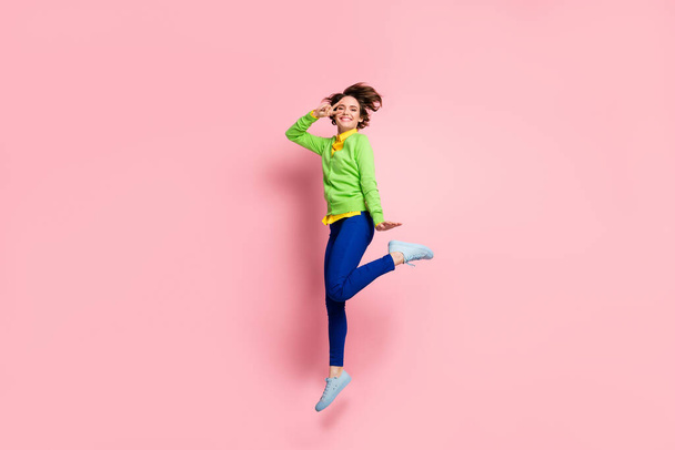 Full length photo of young cheerful crazy girl happy smile jump show peace cool v-sign isolated over pink color background - Фото, зображення