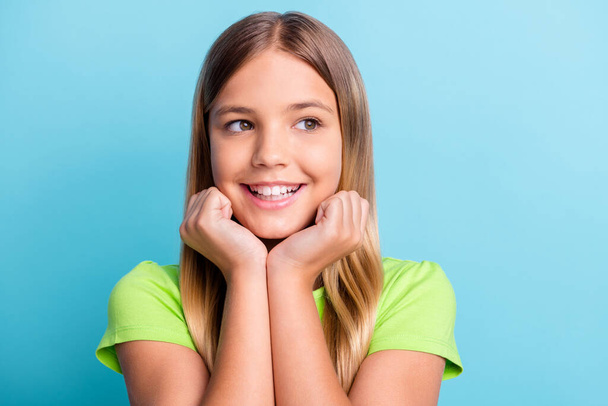 Portrait of young dreamy positive good mood smiling girl look copyspace hold hands chin isolated on blue color background - Zdjęcie, obraz