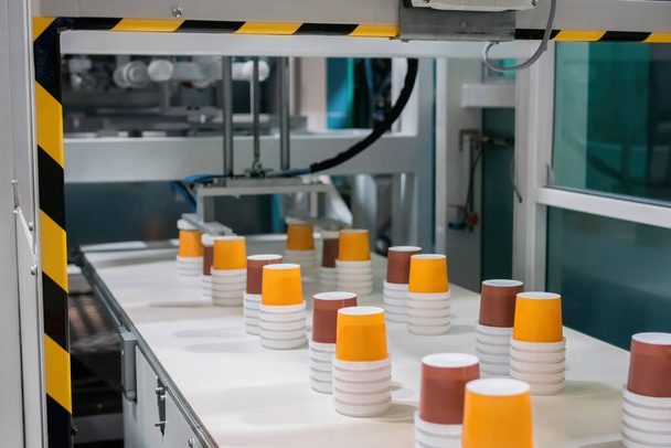 Empty plastic cups moving on conveyor belt at package exhibition - Photo, Image