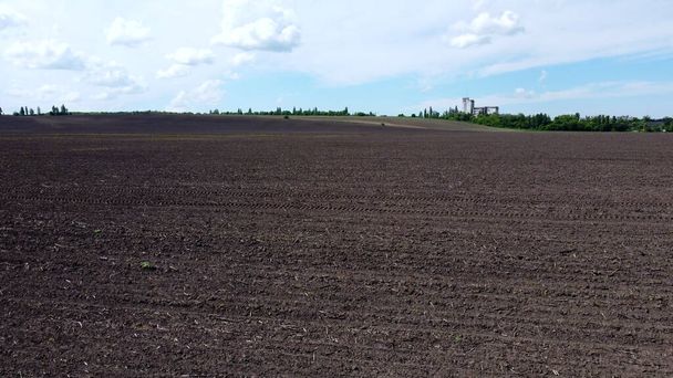 Aerial drone view flight over huge plowed field and blue sky. - Photo, Image