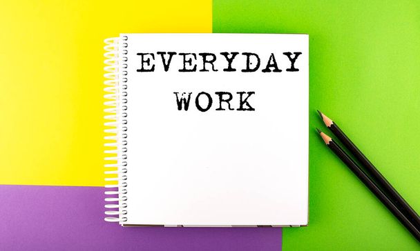 Minimo spazio di lavoro: sketchbook sullo sfondo colorato con OGNI GIORNO DI LAVORO - Foto, immagini