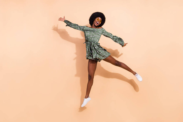 Full body photo of young cheerful black girl happy positive smile have fun jump up isolated over beige color background - Foto, immagini