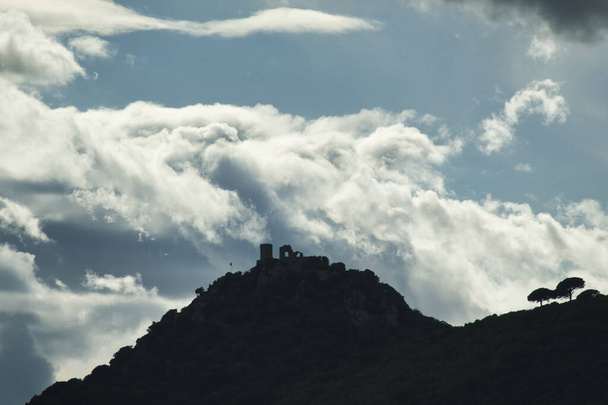 profil d'un château sur une montagne avec ciel nuageux derrière - Photo, image