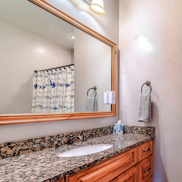 Lavatório oval quadrado na bancada da vaidade do banheiro com armários e espelho de parede emoldurado - Foto, Imagem