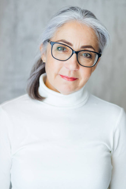 Portrait en gros plan d'une femme aux cheveux gris mature et souriante, optimiste quant à la vie saine des personnes âgées, heureuse grand-mère âgée de 60 ans. - Photo, image