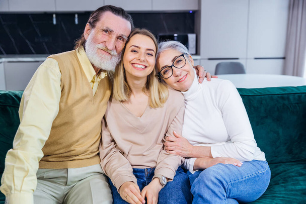 Happy family old grandmother, grandfather and adult granddaughter, cheerfully hugging, smiling loving child, granddaughter, mother, grandmother. - Foto, Bild