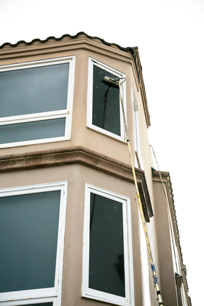 Window Cleaning. Window Washing. Window Washing Service. A professional Window Cleaner washes and rinses windows with Di Ionized Spot Free Water for a Squeekie Clean Service. Window Washing with a extension pole. For a Spot Free Wash and Rinse!  - Photo, image