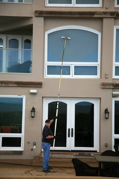 Window Cleaning. Window Washing. Window Washing Service. A professional Window Cleaner washes and rinses windows with Di Ionized Spot Free Water for a Squeekie Clean Service. Window Washing with a extension pole. For a Spot Free Wash and Rinse!  - Foto, imagen