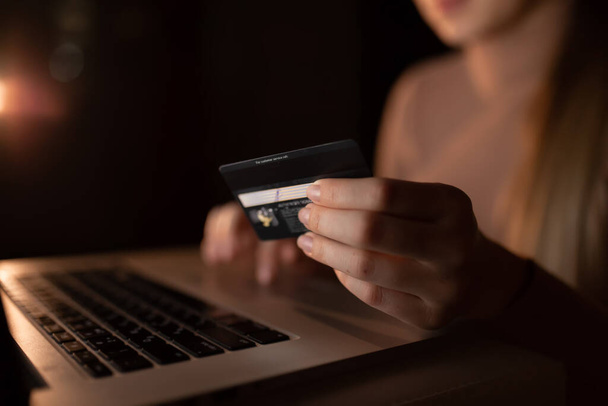 mulher usando laptop e cartão de crédito para compras on-line à noite em casa. - Foto, Imagem