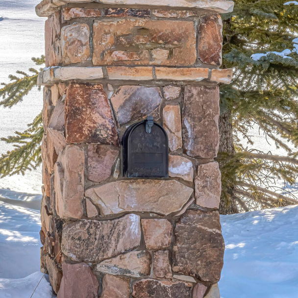 スクエアストーンパークシティユタ州の日差しの強い雪に対するメールボックスと屋外ランプ付きポスト - 写真・画像