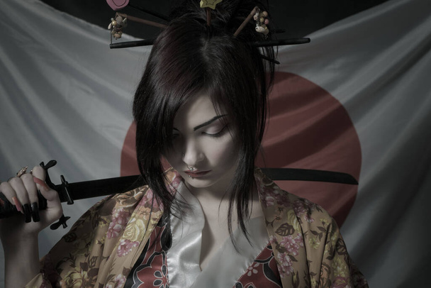 Kawaii japanese girl with katana posing over japanese flag - Photo, image