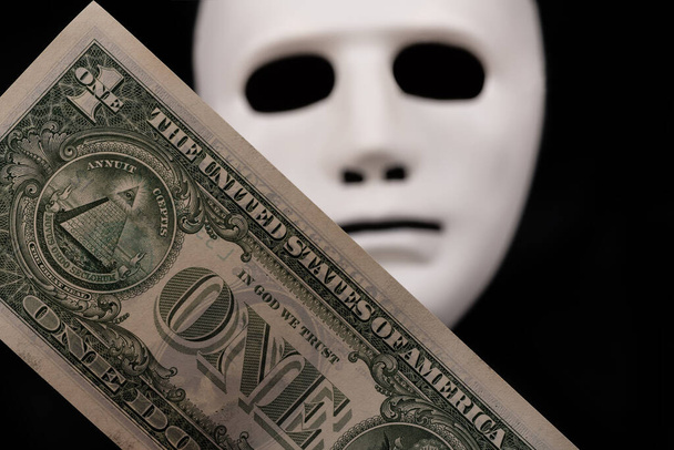 1 долларовая купюра и белая маска на черном фоне - Фото, изображение