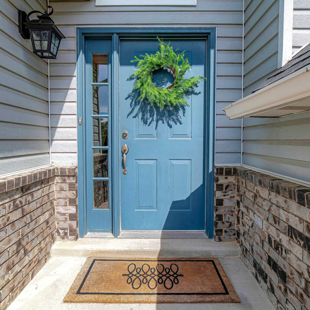 Quadratisch gräulich blaue Haustürsirenen und gewölbte Oberlichtfenster an der Hausfassade - Foto, Bild