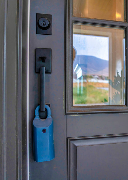 Porta dianteira articulada de madeira cinza vertical de casa com painéis de vidro punho preto e fechadura - Foto, Imagem